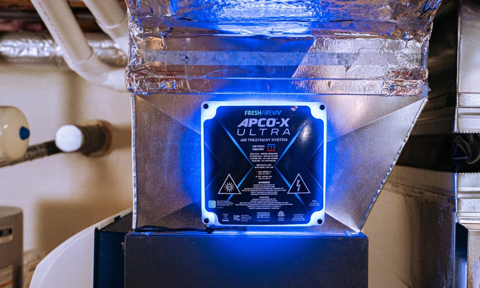 A UV-C air treatment light glowing blue inside HVAC ductwork